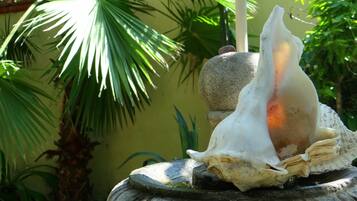 A stone fountain with a large shell and a smaller shell on top.