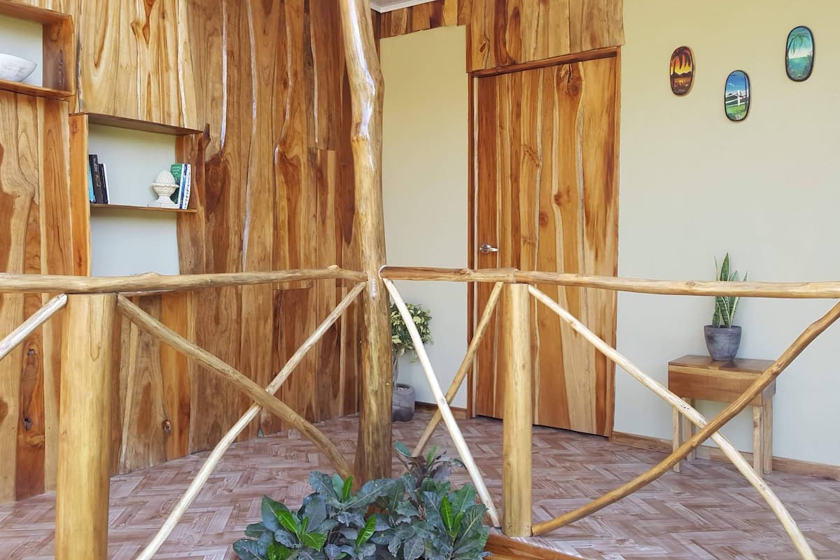 A wooden room with a bamboo fence, a potted plant, and a door.