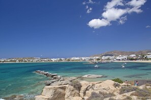 A coastal town with clear turquoise waters, rocky shoreline, and white buildings. - Apartment in Ag.Anna area,fully equipped,semi-basement & very quiet environment. (Νάξος)