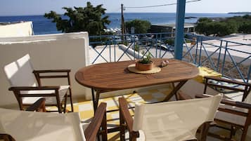 Enjoy a seaside view from this terrace with a table and chairs.