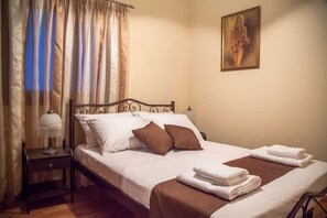 A neatly made bed with white and brown bedding, a bedside lamp, and a painting on the wall. - Villa Veghera - Join Crete, Seaview, private pool (Kissamos)