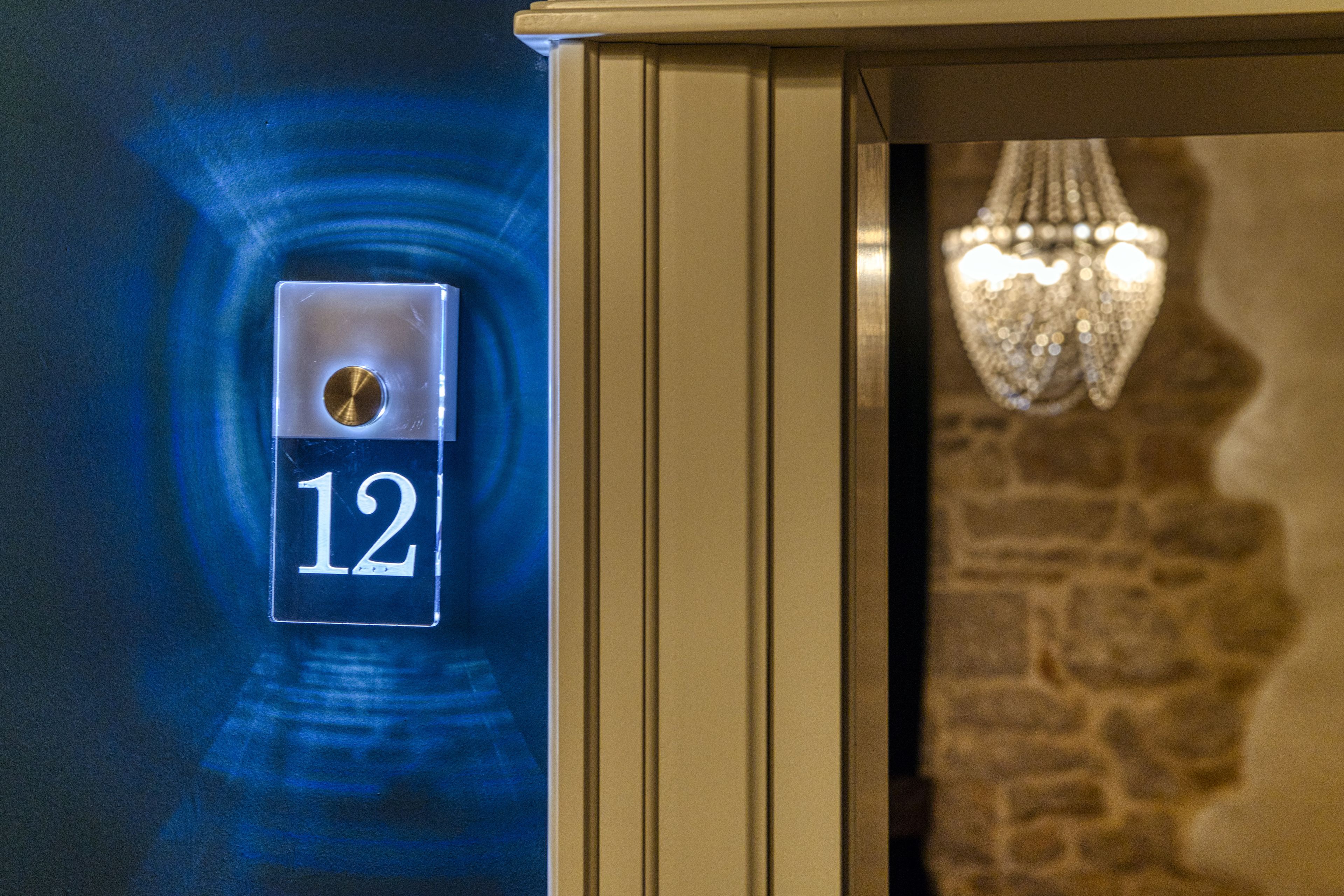 A digital display with the number 12, a door frame, and a chandelier.