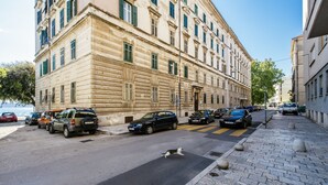 A street with parked cars and a building with classical architecture. - Riva Palace - design rooms (Zadar)