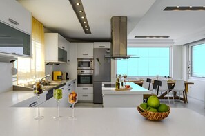 A modern kitchen with a central island, built-in appliances, and a dining area with a view.
