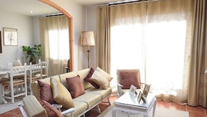 Una sala de estar con sofá, sillones, una mesita de centro y una lámpara.