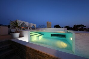 A rooftop pool with a clear view of the surrounding architecture, including a modern building and a tower. - Villa Harmony (Zadar)