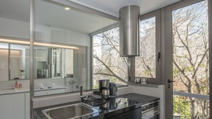 Una cocina moderna con un lavamanos de acero inoxidable, una cafetera y una estufa.