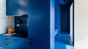 A modern kitchen with blue cabinetry and a marble countertop. - Modern 2 bed/2 bath Acropolis view flat (Αθήνα)