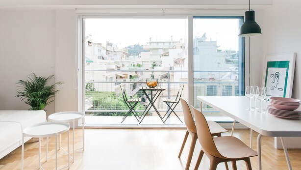 A modern living room with a balcony, white furniture, and a view of the city. - Modern 2 bed/2 bath Acropolis view flat (Αθήνα)