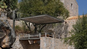 Un bâtiment en pierre avec un escalier menant à une zone abritée.