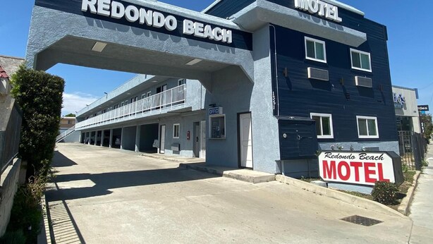 A Redondo Beach Motel with a prominent entrance archway and a sign indicating its name. - Redondo Beach Motel (Gardena)