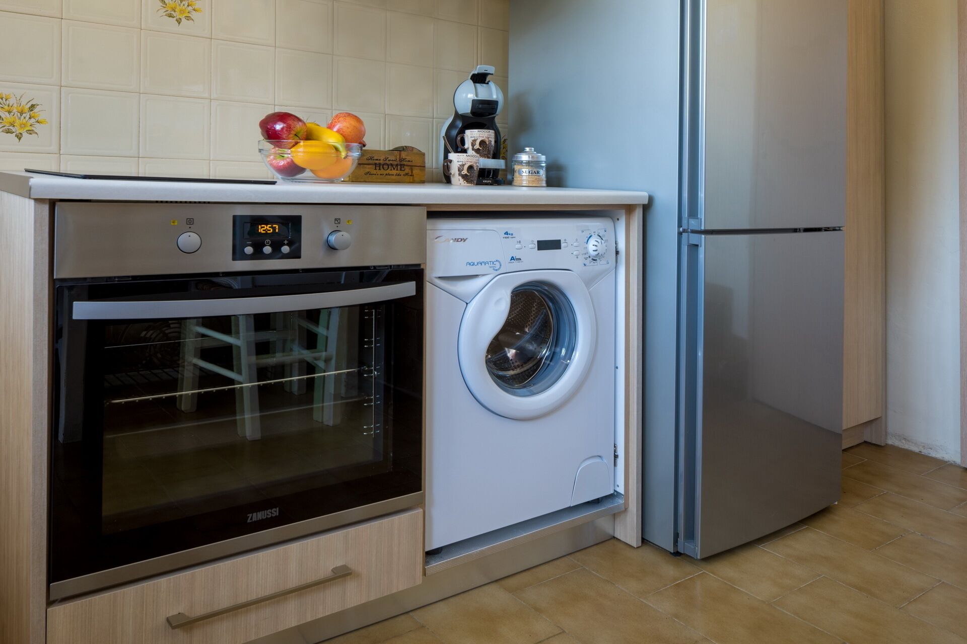 A kitchen with a built-in oven and a front-loading washing machine.