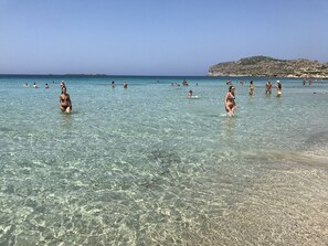 A beach with clear shallow waters and rocky hills in the background. - Maria's Sweet Home. Traditional Renovated house (Καρθιανά)