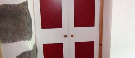 Une porte aux couleurs rouge et blanche, ornée de panneaux circulaires et rectangulaires.