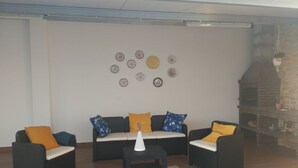 A living room with a sofa set, a coffee table, and decorative plates on the wall. - Tia Rosário Casita in Lourinhã (Lourinhã)