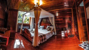 A wooden four-poster bed with a canopy, a bedside table, and a nightstand. - Ecolodge Don Felix (Santa Ana)