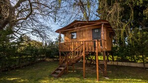 A wooden treehouse with a staircase, a small window, and a star decoration.
