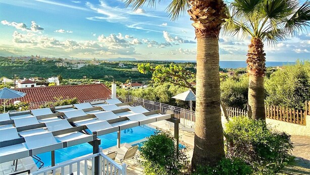 A pool area with lounge chairs and a palm tree. - Eros villa ,private Pool,short drive to beach (Rethymno)