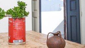 Uma mesa rústica com um vaso de planta e um jarro de cerâmica.