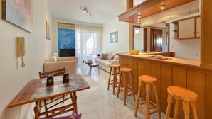A modern kitchen with wooden bar stools, a dining table with chairs, and a bar area. - Two bedroom apartment only 500 meters to the beach (Ιαλυσός)