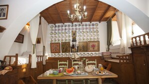 A dining area with a wooden table, chairs, and a chandelier. There are plates and a pitcher on the table. - Arch Villa traditional holiday house on Rhodes (Σορωνή)