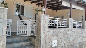 A stone staircase leading to a covered porch with a metal railing and decorative lanterns. - Arch Villa traditional holiday house on Rhodes (Σορωνή)