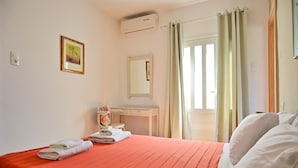 Ein Hotelzimmer mit einem Bett, einem Schreibtisch, einem Stuhl, einem Spiegel und einem Vorhangfenster.