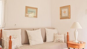 Ein Zimmer mit einem Bett, einem kleinen Tisch mit einer Lampe und zwei Wand-Klimaanlagen.