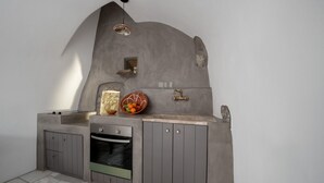 Eine Küche mit eingebautem Ofen, Spüle und Obstschale auf der Arbeitsfläche.