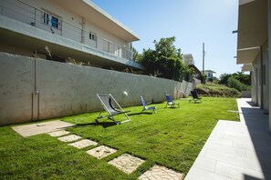 Relax in a serene outdoor space with lounge chairs and a beautifully manicured lawn.