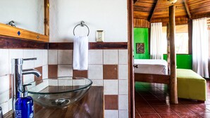 A bathroom with a glass bowl sink, a white towel, and a wooden ceiling. - Playa Junquillal Eco Resort (Santa Cruz)