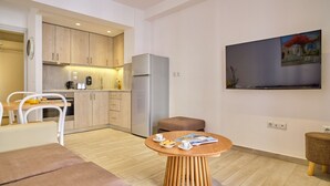 Een moderne keuken met houten kastjes, een koelkast en een eethoek met een ronde houten tafel.