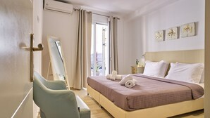Een hotelkamer met een bed, een stoel, een nachtkastje en uitzicht.