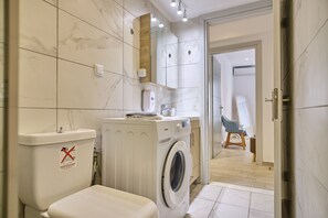 Regadera, secadora de cabello, toallas, papel de baño 