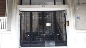 L'ingresso di un edificio con un'ampia cancellata nera, il numero 39 e un piccolo finestrino sopra.