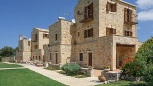 Un bâtiment en pierre doté de nombreux balcons, d’un chemin pavé et d’une pelouse bien entretenue.