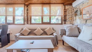 Una habitación acogedora con un sofá, una mesa de centro y una pared de piedra.