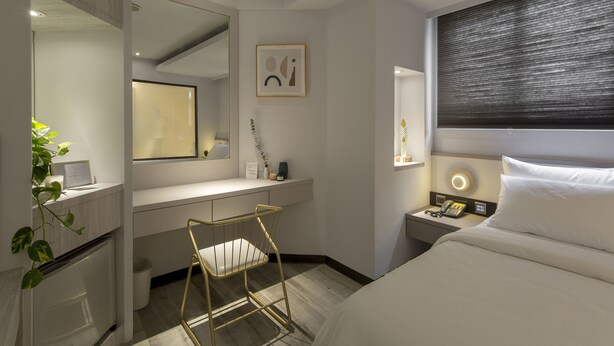 A modern hotel room with a bed, bedside table, nightstand, and a desk with a chair. - Peng Apartment (Taipei)