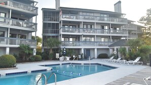 Un hôtel à plusieurs étages doté d’une piscine, d’un espace extérieur aménagé et de balcons.
