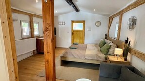 Ein geräumiges Schlafzimmer im Dachgeschoss mit einem großen Bett, einer Couch und einem kleinen Tisch.