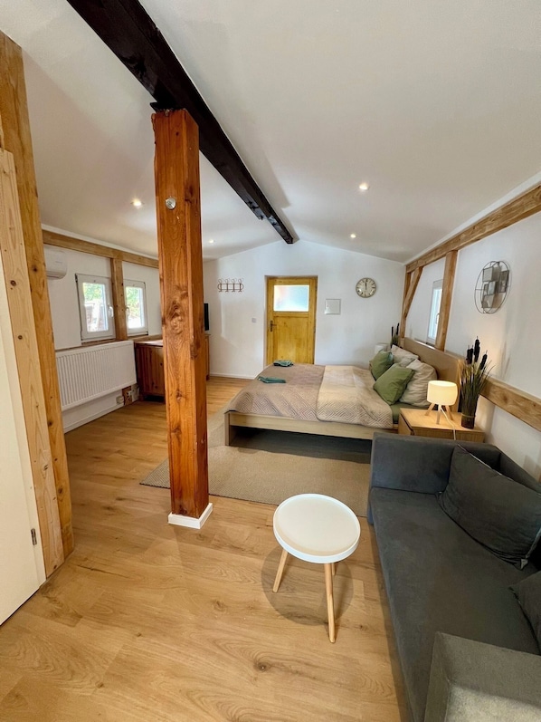 Une chambre spacieuse située dans les combles, avec un grand lit, un canapé et une petite table.