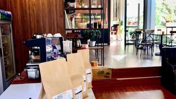 Ein Café mit Holzinnenraum, einer Weltkarte an der Wand und einer Kaffeebar.