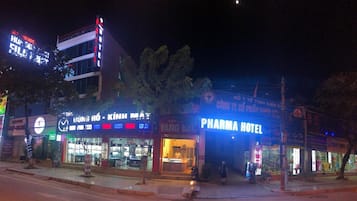 A hotel with a prominent sign, a storefront with various brands, and a visible entrance.