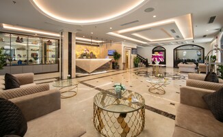 Un amplio vestíbulo con mostrador de recepción, asientos cómodos y una fuente decorativa.