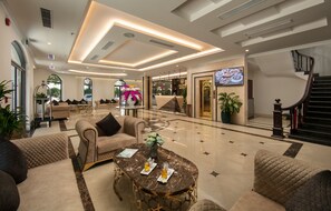 A spacious lobby with a marble floor, comfortable seating, a reception desk, and a staircase. - Halios Hotel Halong (Ha Long)