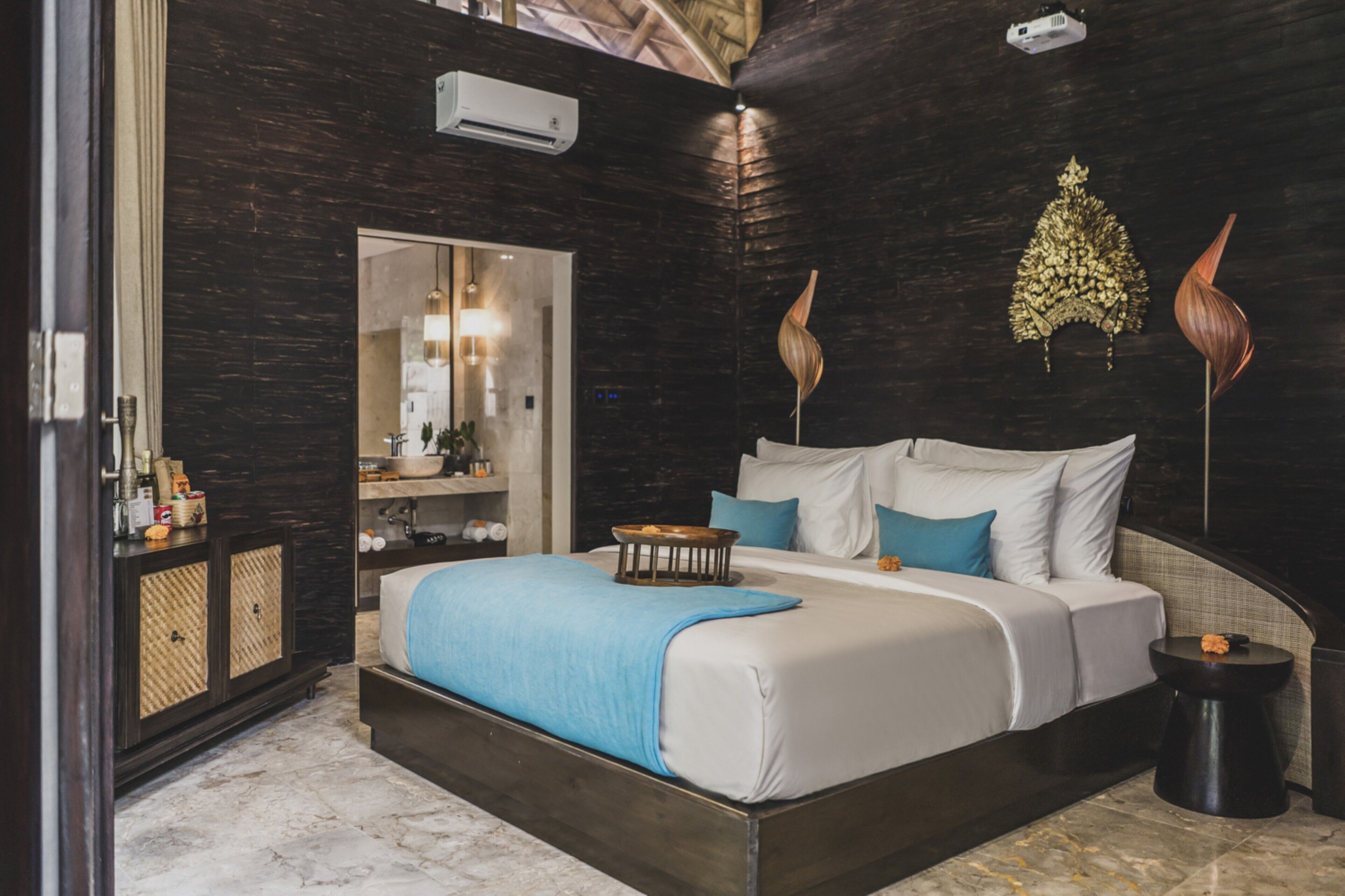 A modern bedroom with a large bed, a nightstand, a mirror, and a wardrobe.