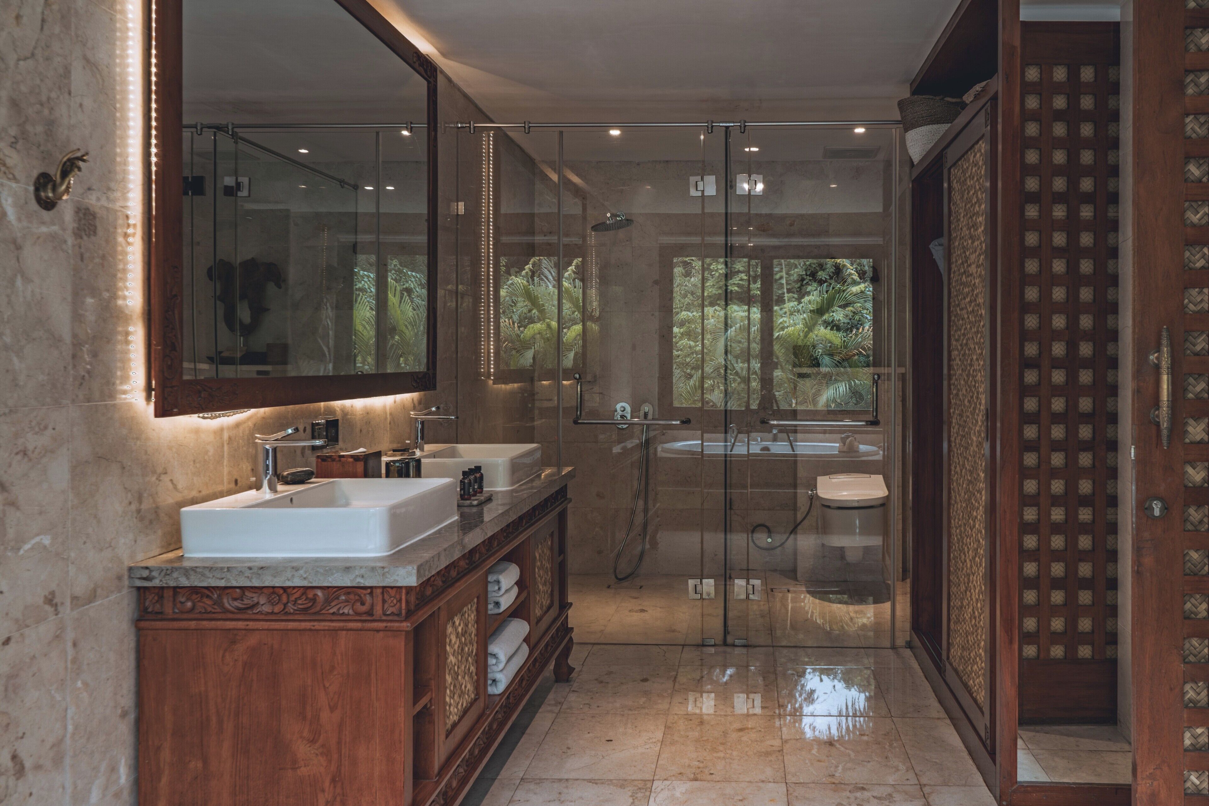 Une salle de bain moderne avec deux lavabos, un grand miroir et une douche à l’italienne.