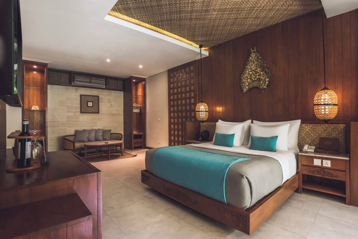 Een moderne hotelkamer met een groot bed, een bureau en een zithoek.
