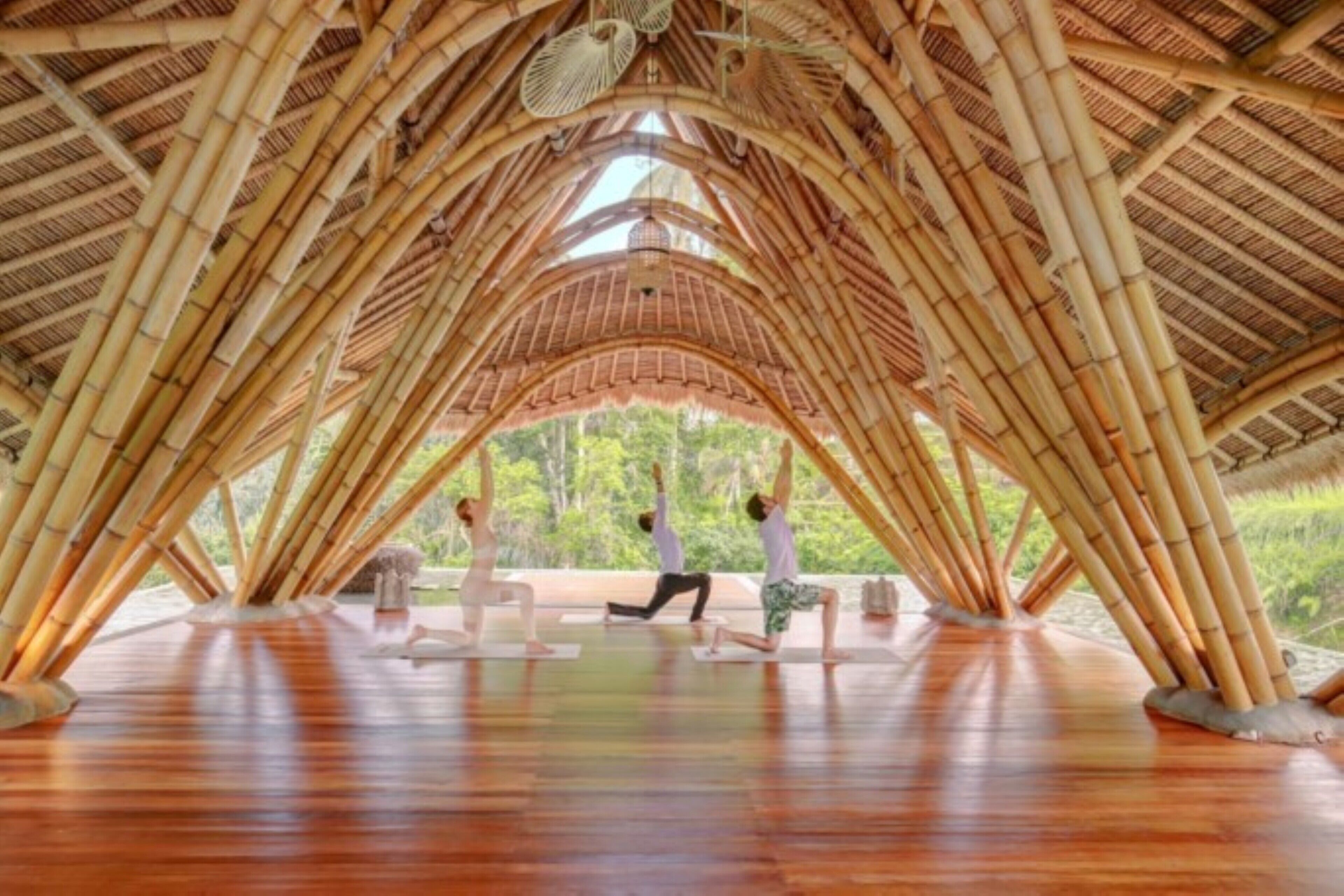 Ein Innenraum mit Bambusdecke und Holzboden, mit einer Yogamatten-Ecke.
