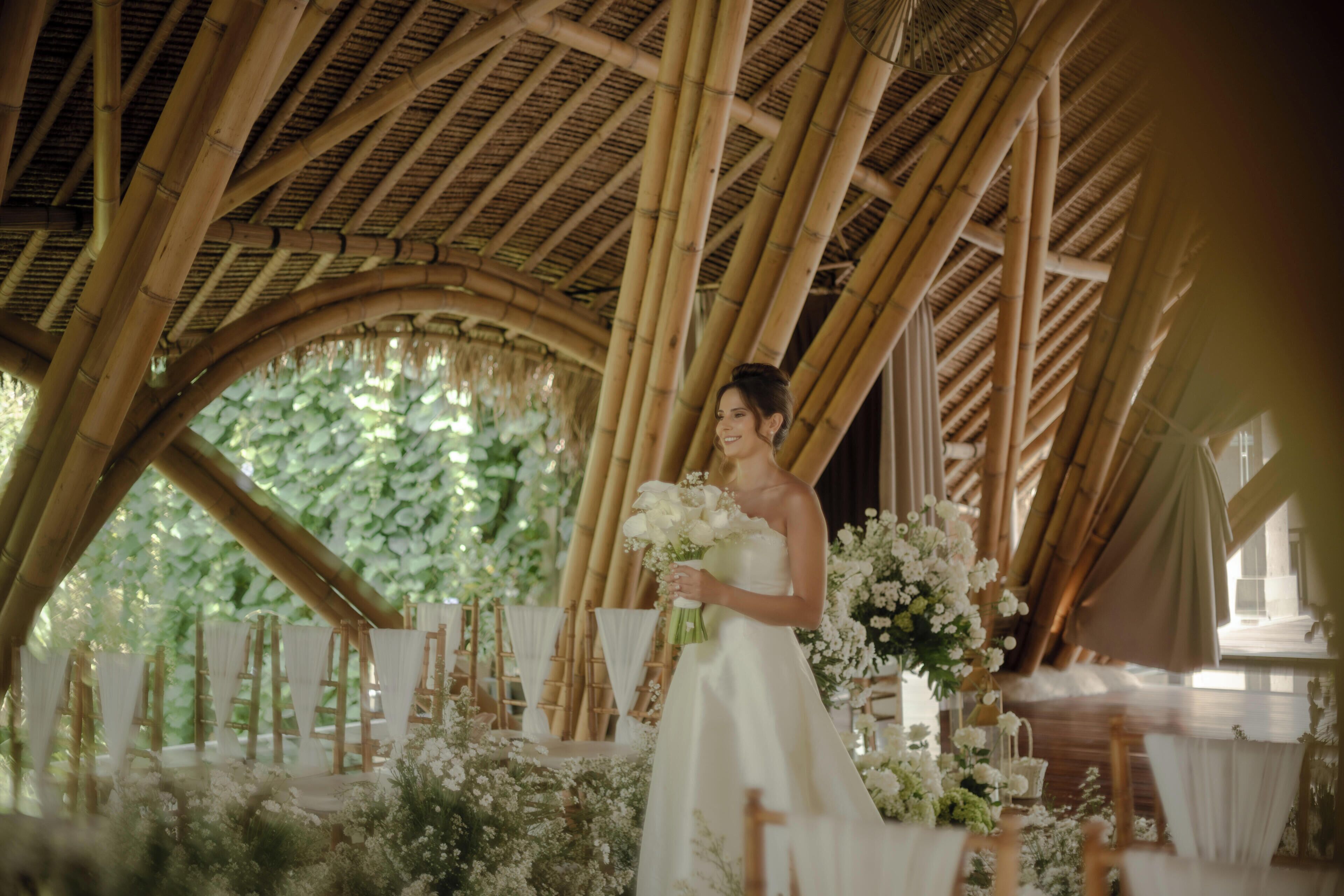 Une cérémonie de mariage se déroulant sous une structure en bambou, agrémentée de compositions florales.